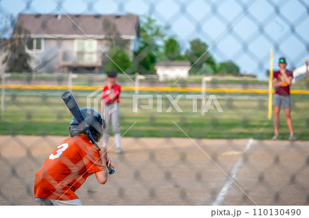 Parent view behind a chain link fence and home plate with a batter ready Parent view behind a chain link fence and home plate with a batter ready 110130490