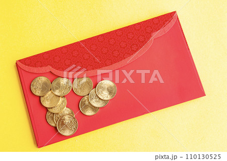 Top view of red envelopes with golden coins on yellow cover with customizable space for text. Top view of red envelopes with golden coins on yellow cover with customizable space for text. 110130525