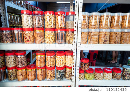 Variety of Chinese New Year cookies in jars place on shelf of retail for sale 110132436