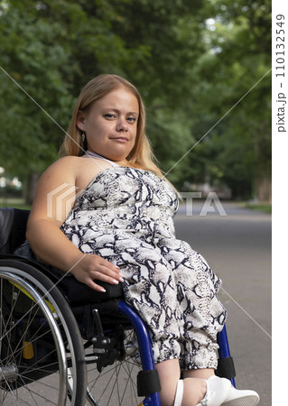International Wheelchair Day , March 1st Smiling. Pretty Young Woman With Short Stature Sitting In Wheel Chair In Outdoor. Park On Background. Person With Special Needs Enjoys Social Life. Vertical. International Wheelchair Day , March 1st Smiling. Pretty Young Woman With Short Stature Sitting In Wheel Chair In Outdoor. Park On Background. Person With Special Needs Enjoys Social Life. Vertical. 110132549