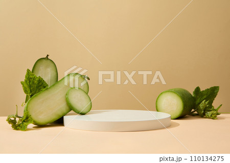 Several halves of winter melon are placed on surface with a round podium. Minimal podium display for cosmetic product presentation Several halves of winter melon are placed on surface with a round podium. Minimal podium display for cosmetic product presentation 110134275