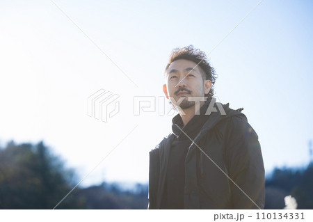 真剣な表情で遠くを見つめる40代男性の上半身 真剣な表情で遠くを見つめる40代男性の上半身 110134331