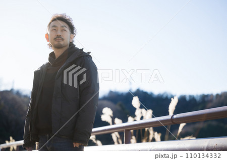 真剣な表情で遠くを見つめる40代男性の上半身 110134332