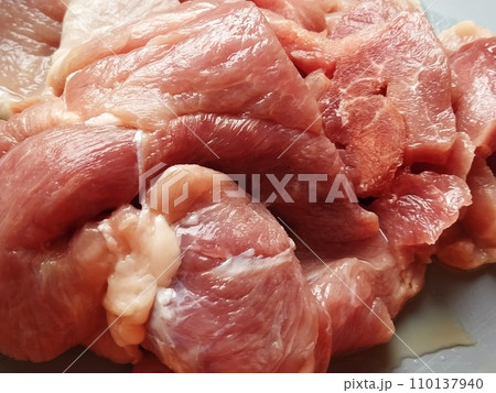 A juicy large piece of pork meat on a gray surface. Meat thawed or steamed, from which blood juice flows. Delicious fresh meat for cutting and cooking 110137940