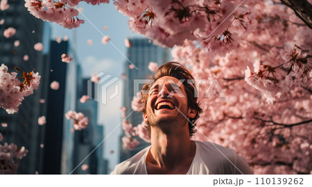 Modern happy young smiling man with cherry blossoms in background of metropolis city. 110139262