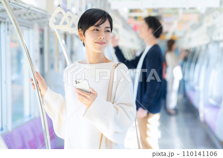 電車でスマホを見る若い女性　撮影協力「京王電鉄株式会社」 110141106
