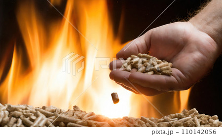 Fiery Embrace: Wood Pellets Ignite Warmth in Hand. Fiery Embrace: Wood Pellets Ignite Warmth in Hand. 110142056