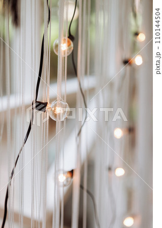 Hanging bulbs casting warm glow. 110144504