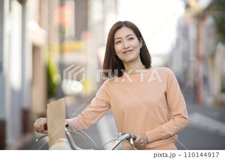 自転車で買い物に行くミドルの女性 自転車で買い物に行くミドルの女性 110144917