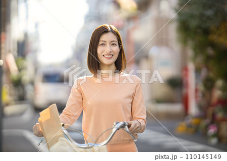 自転車で買い物に行くミドルの女性 自転車で買い物に行くミドルの女性 110145149