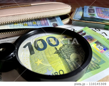 Magnifying glass on different Euro banknotes Magnifying glass on different Euro banknotes 110145309