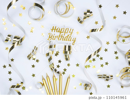 background with golden stars, serpentine and candles ,concept for celebrating a birthday, anniversary or party in Gold tones 110145961
