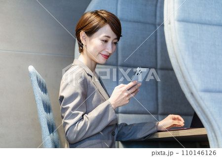 パーソナルブースでスマホを使う女性　撮影協力：WEEK芝大門（サンフロンティア不動産） 110146126