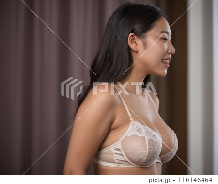 asian woman in lingerie looking out the window 110146464