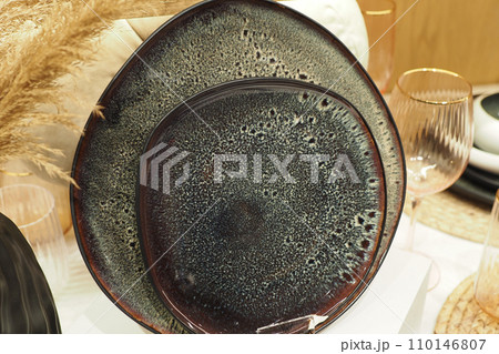 round bowl or ceramic plate on napkin on wooden table. 110146807