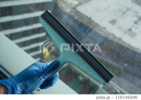 person hand in gloves cleaning window glass person hand in gloves cleaning window glass 110146896