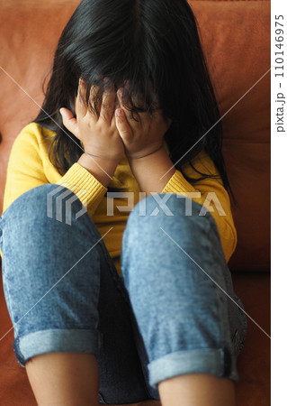 a upset child girl cover her face with hand  110146975