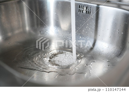 Water dripping from faucet tap at kitchen. Closeup 110147144
