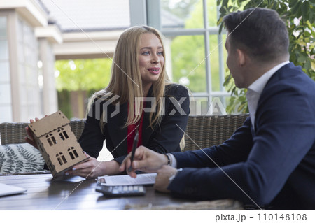 Smiling realtor helps businessman with choosing house Smiling realtor helps businessman with choosing house 110148108