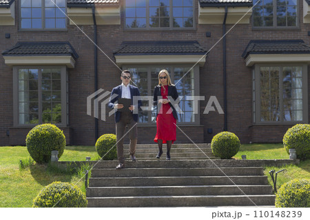 Estate agents colleagues on cottage residence steps 110148239