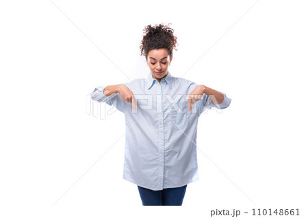 young fashion woman caucasian woman with curly black hair gathered in a ponytail wears a blue shirt young fashion woman caucasian woman with curly black hair gathered in a ponytail wears a blue shirt 110148661