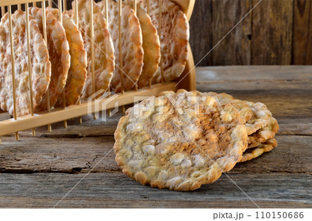 Typical South Tyrolean local crunchy flat bread, so called schuettelbrot, with wooden shelf Typical South Tyrolean local crunchy flat bread, so called schuettelbrot, with wooden shelf 110150686