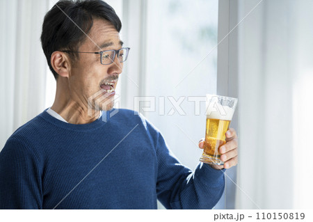 ビアグラスを持った50代半ばの男性　 110150819