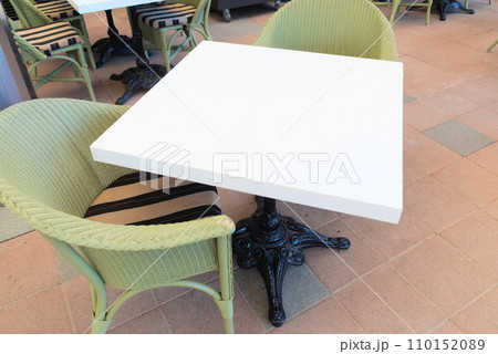 屋外のカフェに設置された椅子とテーブル 110152089