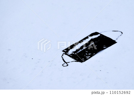 雪が積もった道路に落ちている黒のマスクの写真素材 [110152692] - PIXTA