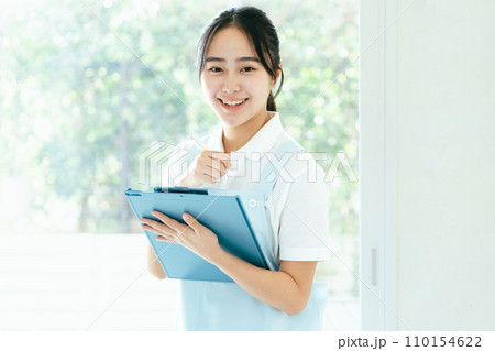 窓際に立つ介護士の若い女性 110154622