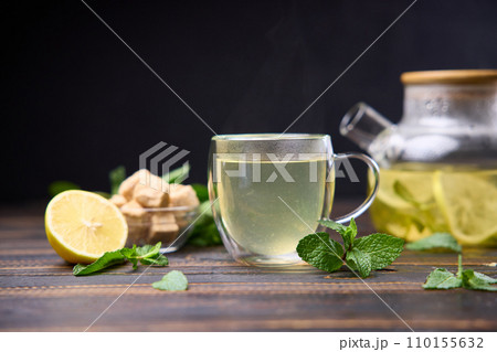 natural organic herbal tea with lemon and mint in glass teapot on a wooden table 110155632