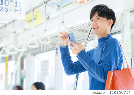電車でスマホを見る若い男性 電車でスマホを見る若い男性 110156714