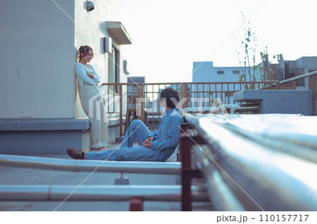 屋上で話す男女 110157717