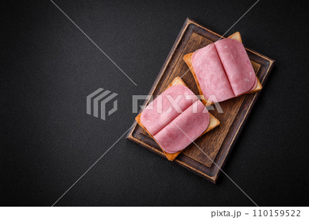 Delicious sandwich with toast bread, ham, tomatoes, salt and spices Delicious sandwich with toast bread, ham, tomatoes, salt and spices 110159522