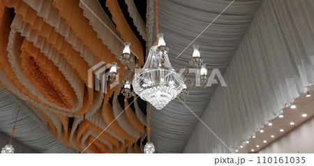 decorative Crystal chandelier lamp on the ceiling in weeding banquet hall. 110161035