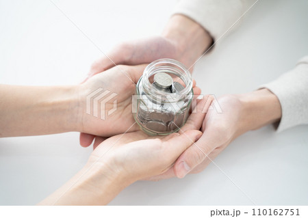 手に収まる貯金、コインが詰まった透明な瓶 手に収まる貯金、コインが詰まった透明な瓶 110162751
