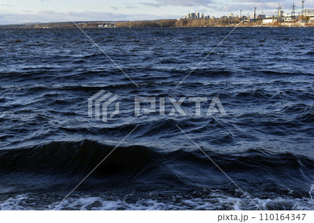 Black waves of the reservoir in winter in the mountains. The dark waters of the reservoir in Yekaterinburg. Black waves of the reservoir in winter in the mountains. The dark waters of the reservoir in Yekaterinburg. 110164347