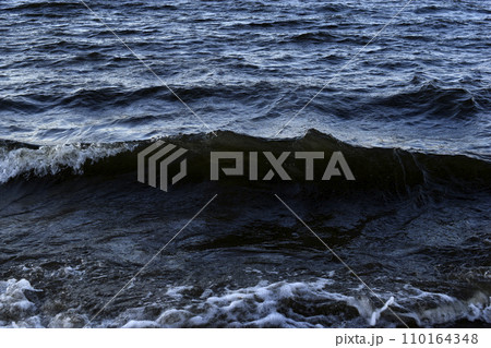 Black waves of the reservoir in winter in the mountains. The dark waters of the reservoir in Yekaterinburg. Black waves of the reservoir in winter in the mountains. The dark waters of the reservoir in Yekaterinburg. 110164348