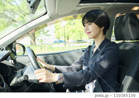 車を運転する30代女性会社員 車を運転する30代女性会社員 110165130