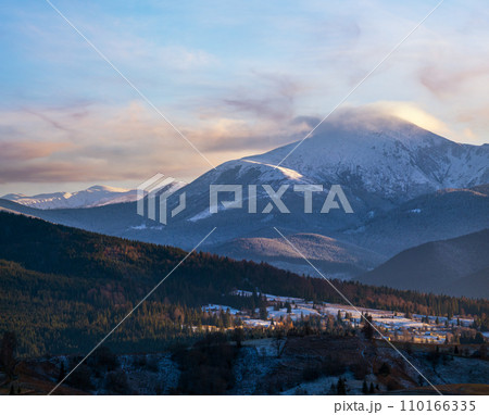 Late autumn mountain pre sunset scene with snow covered tops in far. Picturesque traveling, seasonal, nature and countryside beauty concept scene. Carpathians, Ukraine. 110166335