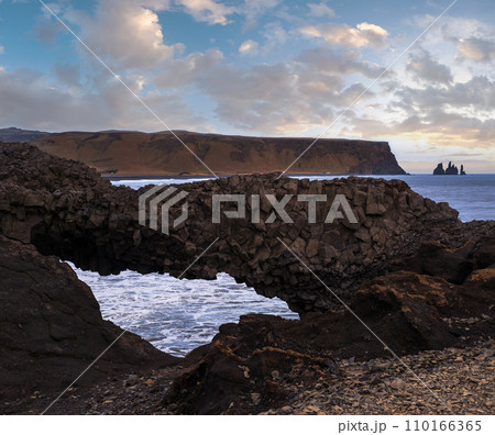 Picturesque autumn evening view to Reynisfjara ocean  black volcanic sand beach and rock formations from Dyrholaey Cape, Vik, South Iceland. Mount Reynisfjall on the background. 110166365