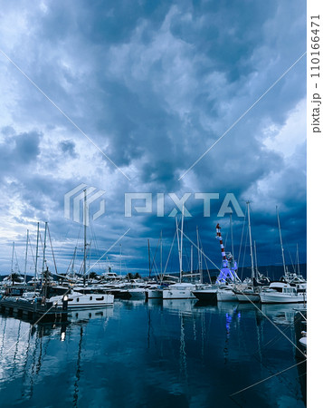 Marina with sailing yachts and port crane against the twilight sky Marina with sailing yachts and port crane against the twilight sky 110166471