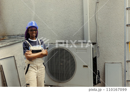 Portrait of cheerful knowledgeable professional proud of work done, standing in front of fixed hvac system. Specialist contracted by client happy with smooth servicing of internal condenser parts 110167099