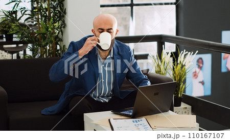 Company worker in startup office examining monthly statistics, trying to increase small business profit. Businessman looking at report on laptop to gather marketing information. Company worker in startup office examining monthly statistics, trying to increase small business profit. Businessman looking at report on laptop to gather marketing information. 110167107