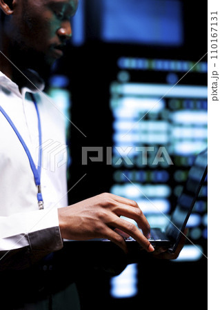 Admin checking event logs and diagnostic tools using laptop to identify server issues root cause. Technician looking over supercomputer operating system configuration settings 110167131