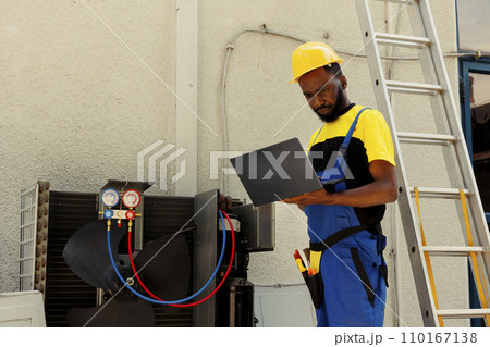 African american specialist hired after home owner complaints about significant increase in energy bills. Knowleadgeable engineer using ac gauges vacuum pump to detect refrigerant leaks African american specialist hired after home owner complaints about significant increase in energy bills. Knowleadgeable engineer using ac gauges vacuum pump to detect refrigerant leaks 110167138