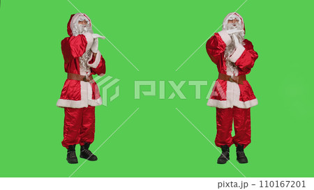 Saint nick feeling exhausted in studio, showing timeout symbol to express burnout while he is overworked. Winter festive character in red costume being tired, rejecting work on greenscreen. 110167201