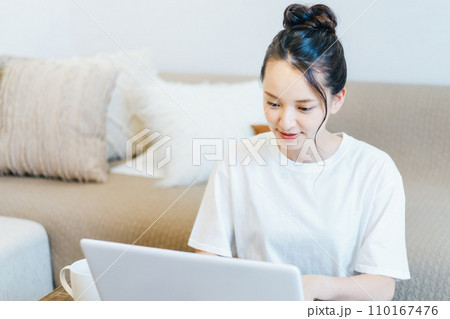 パソコンを見ながらお茶を飲む女性 パソコンを見ながらお茶を飲む女性 110167476