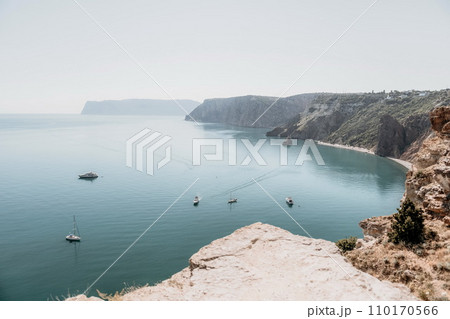 Aerial view from above on calm azure sea and volcanic rocky shores. Small waves on water surface in motion blur. Nature summer ocean sea beach background. Nobody. Holiday, vacation and travel concept Aerial view from above on calm azure sea and volcanic rocky shores. Small waves on water surface in motion blur. Nature summer ocean sea beach background. Nobody. Holiday, vacation and travel concept 110170566