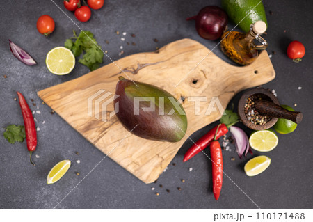 Tropical mango fruit on a wooden cutting board Tropical mango fruit on a wooden cutting board 110171488